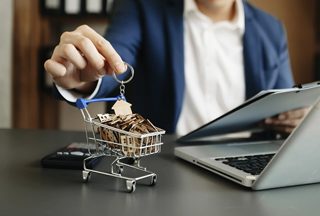 Persona con carrito de compras lleno de casas